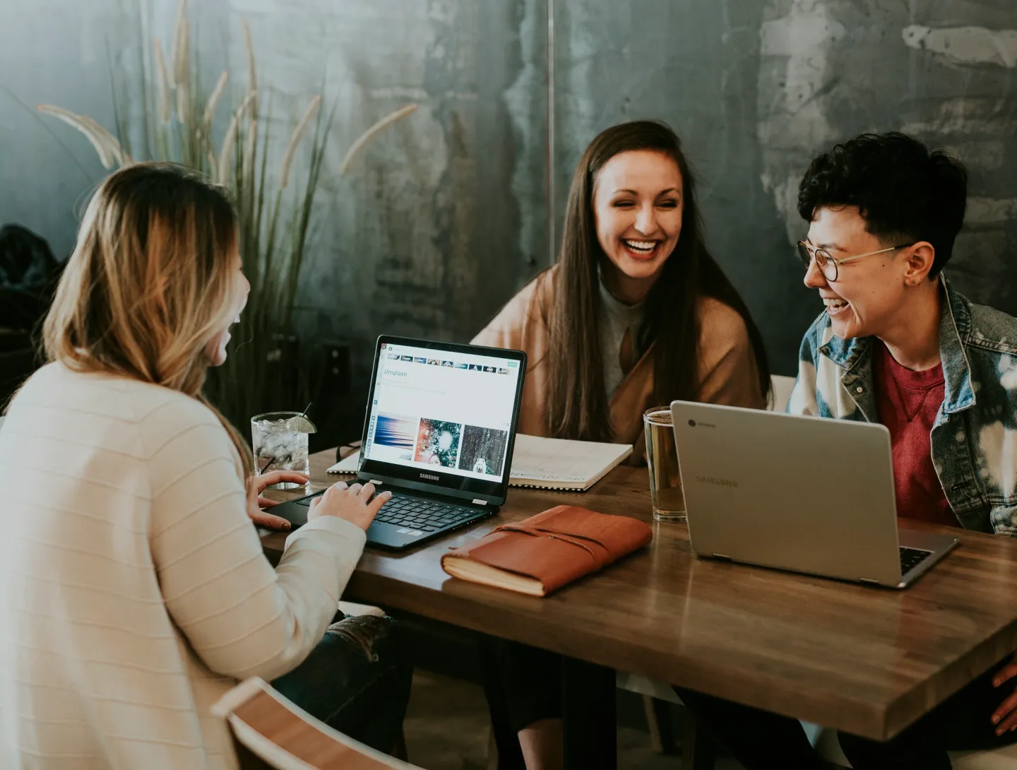 three people sitting together with their computers