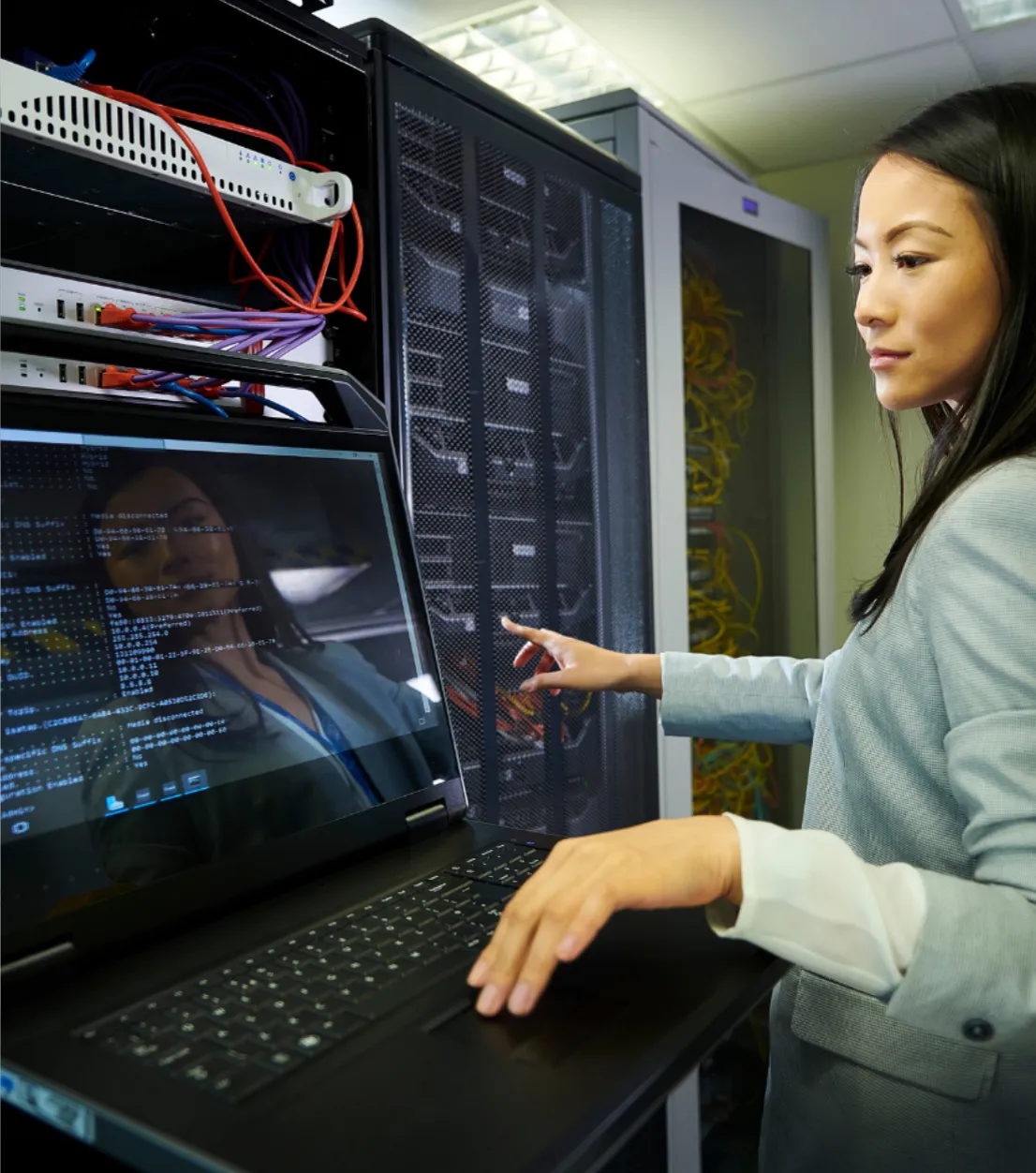 Person with computer in a server room